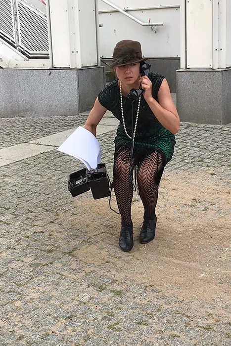 Schauspielerin Britta Bothe mit einem alten Telefon bei einer Krimi & Tour Stadtrally